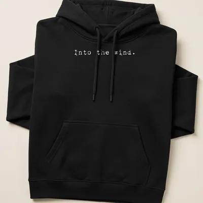 Minimalist white t-shirt with the text 'Into the wind.' — printed on a unisex hoodie