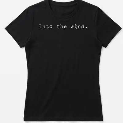 Minimalist white t-shirt with the text 'Into the wind.' — printed on a women's shirt