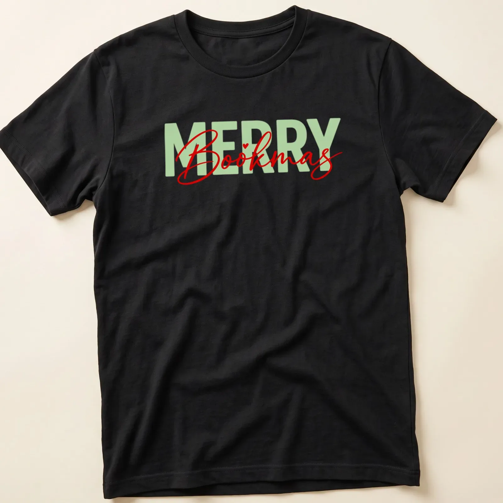 Modern calligraphy design saying Merry Bookmas for book lovers in festive colors — printed on a unisex t-shirt