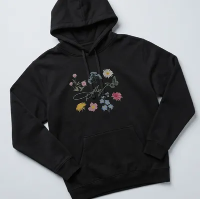 Charming pastel illustration of a butterfly and colorful flowers with Dolly signature — printed on a unisex hoodie