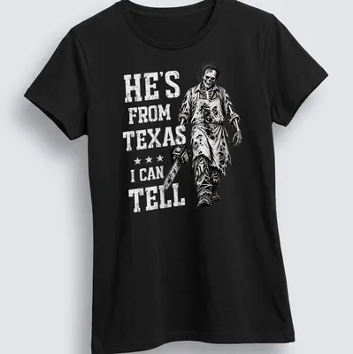 Chainsaw skeleton holding a chainsaw with text: He's From Texas I Can Tell. — printed on a women's shirt