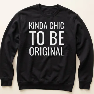 White t-shirt with the text 'KINDA CHIC TO BE ORIGINAL' in modern bold font. — printed on a unisex sweatshirt