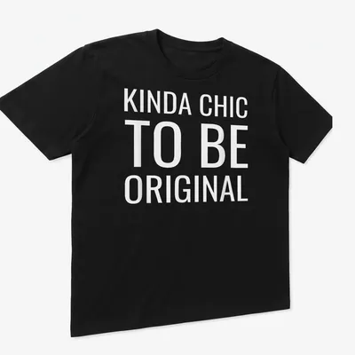 White t-shirt with the text 'KINDA CHIC TO BE ORIGINAL' in modern bold font. — printed on a unisex t-shirt (angled view)