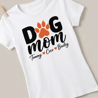 Black, orange, and white typography T-shirt with paw print and dog mom text. — printed on a women's shirt