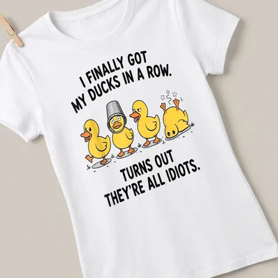 Cartoon design featuring yellow ducks with humorous text about organizing them. — printed on a women's shirt