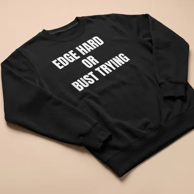 Bold typography t-shirt with the quote 'EDGE HARD OR BUST TRYING' on a white background — printed on a unisex sweatshirt