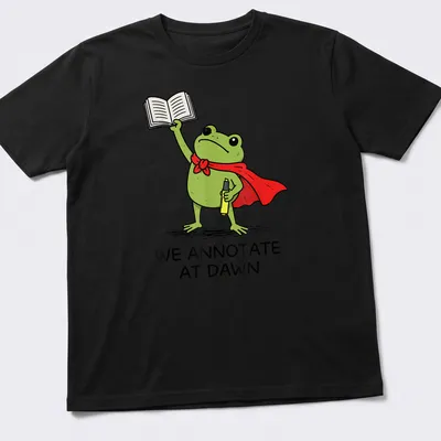 Cartoon frog T-shirt with the phrase 'We Annotate At Dawn' in playful font