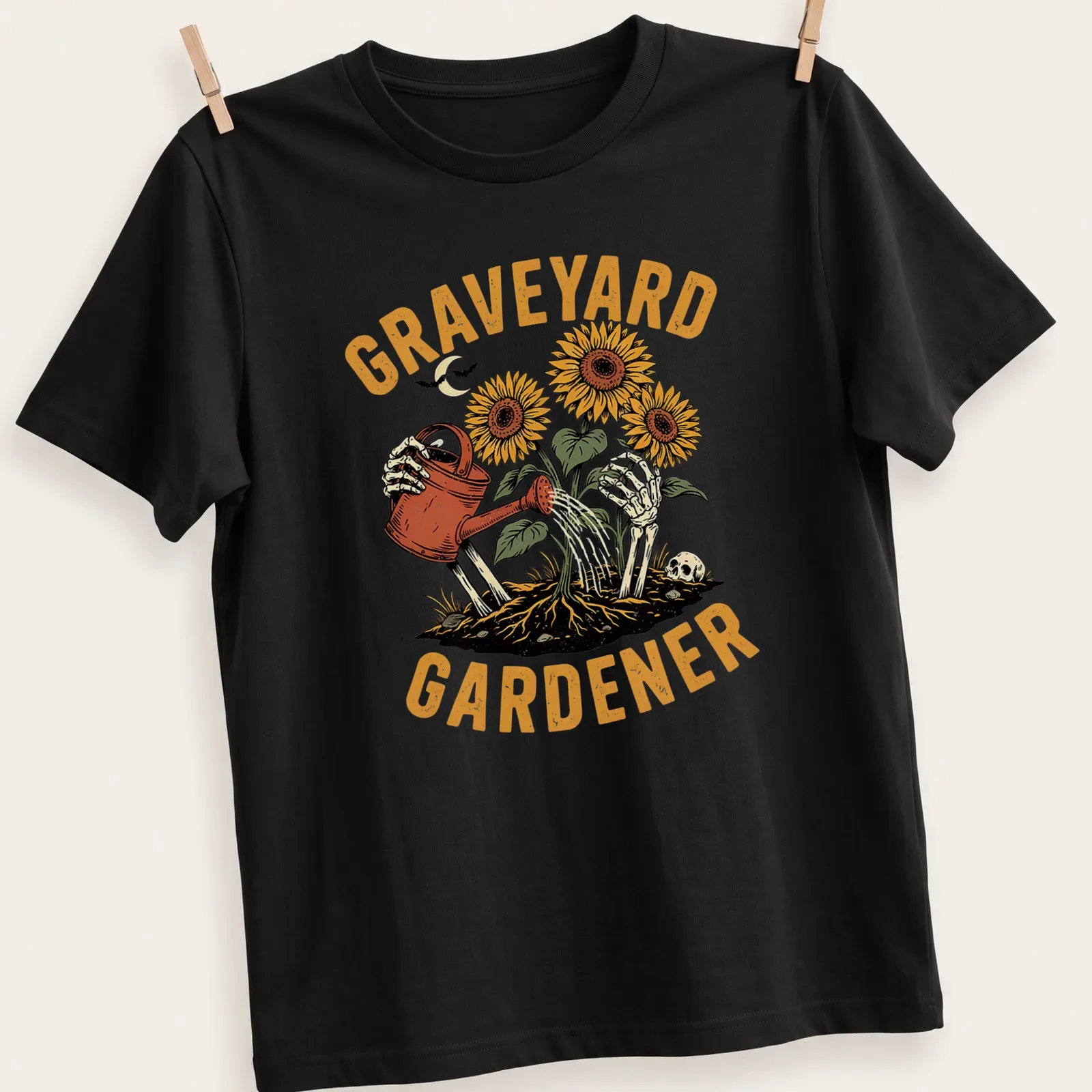 Vintage illustration of a skeleton watering sunflowers with the text 'GRAVEYARD GARDENER' — printed on a unisex t-shirt