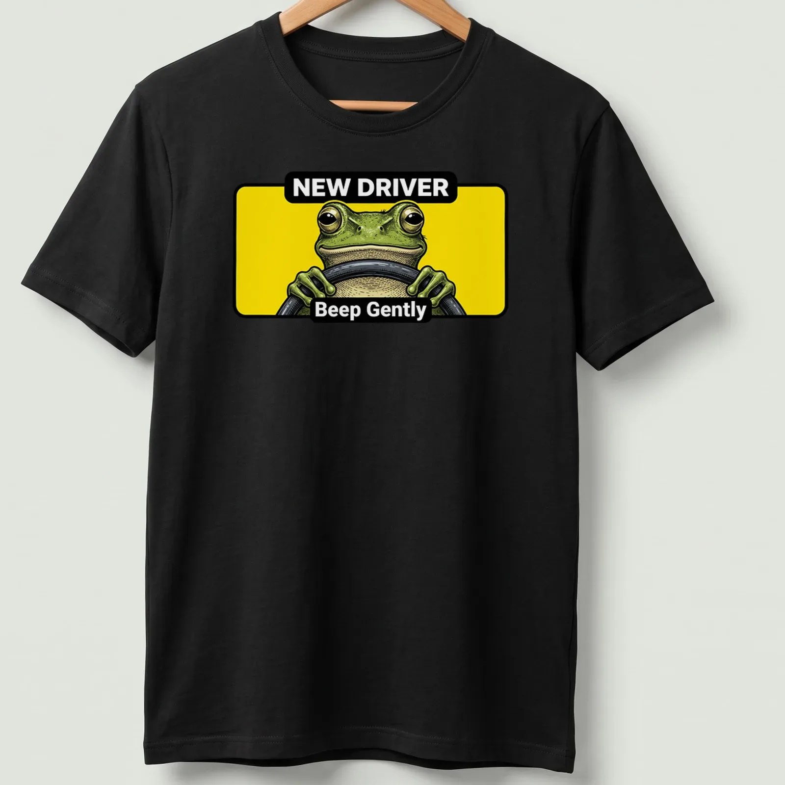 Cartoon green frog with text 'NEW DRIVER Beep Gently' in yellow and black — printed on a unisex t-shirt