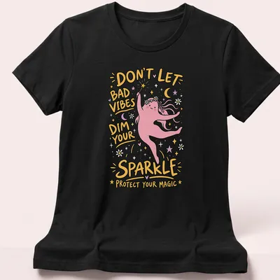 Playful cartoon t-shirt featuring a magic character with vibrant colors and positive text — printed on a women's shirt