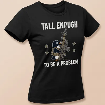 Cartoon penguin with a gun and the text 'Tall Enough To Be A Problem' in black and white — printed on a women's shirt