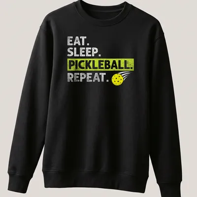 Bold typography t-shirt featuring Eat Sleep Pickleball Repeat in yellow, green, and white — printed on a unisex sweatshirt
