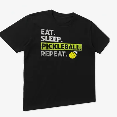 Bold typography t-shirt featuring Eat Sleep Pickleball Repeat in yellow, green, and white — printed on a unisex t-shirt (angled view)