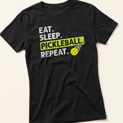 Bold typography t-shirt featuring Eat Sleep Pickleball Repeat in yellow, green, and white — printed on a women's shirt