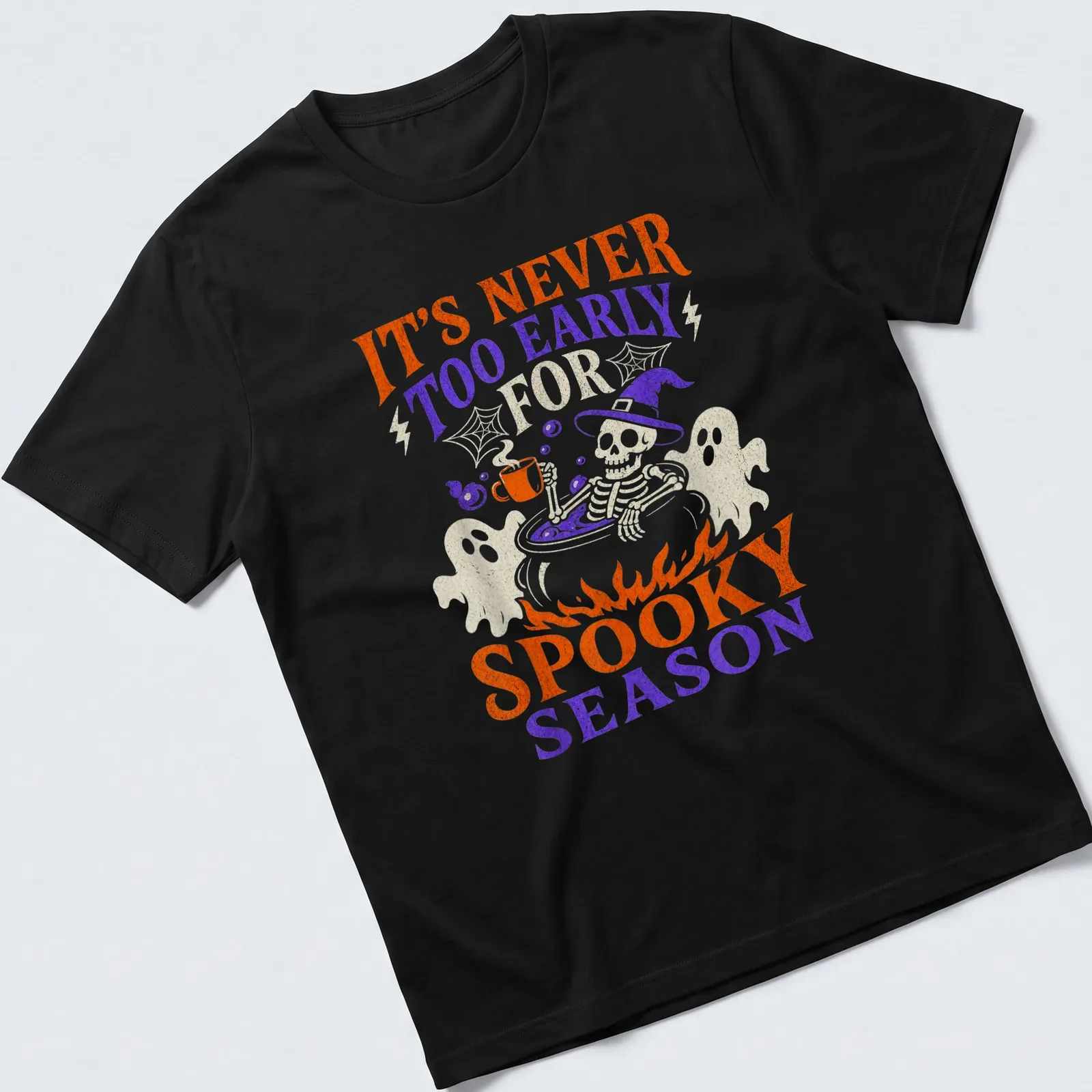 Playful cartoon graphic of a skeleton in a cauldron with Halloween text — printed on a unisex t-shirt