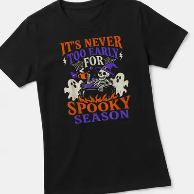 Playful cartoon graphic of a skeleton in a cauldron with Halloween text — printed on a women's shirt