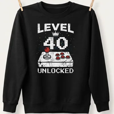 Retro distressed t-shirt with 'LEVEL 40 UNLOCKED' above a video game controller in bright colors — printed on a unisex sweatshirt