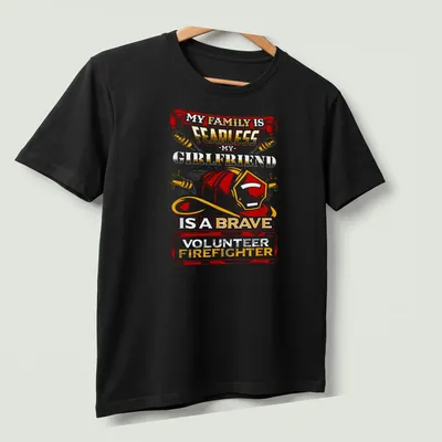 Vintage-style t-shirt celebrating a brave volunteer firefighter girlfriend with bold text and helmet graphic. — printed on a unisex t-shirt (angled view)