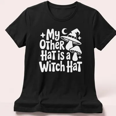 Funny shirt featuring the text My Other Hat Is A Witch Hat with an illustration of a witch hat — printed on a women's shirt