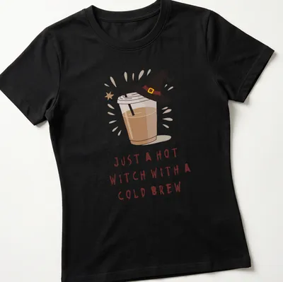 Kawaii illustration of a witch with a cold brew and playful text in brown, cream, and yellow — printed on a women's shirt